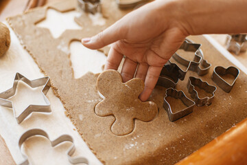 Hand cutting gingerbread dough in christmas man shape. Christmas holiday tradition