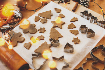 Making gingerbread cookies, Christmas holiday tradition. Raw gingerbread dough with metal cutters