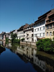 Fototapeta na wymiar View of the picturesque houses along the River Ill of Strasbourg with reflections in the still river
