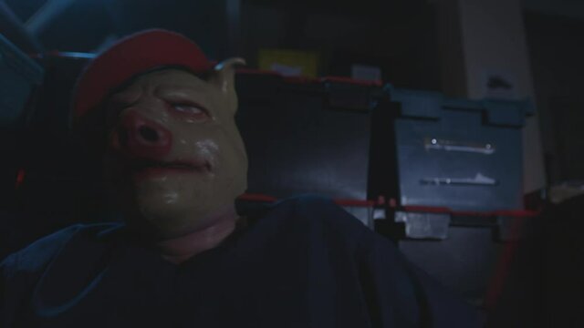 Man in pig mask suddenly hyperventilates and struggles while tied to a chair