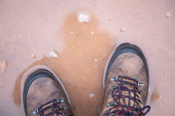 Wanderschuhe in einer Wasserlache