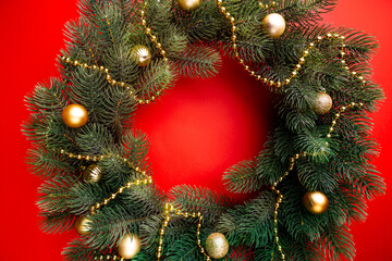 Fototapeta na wymiar Beautiful Christmas wreath on red background. Christmas holidays composition