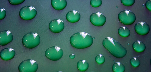 Water drops on dark surface. Abstract background.  Natural pattern close up photo. 
