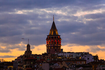 Galata Tower at dusk with lights on. Clouds on the sky. Istanbul background photo. 