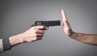 Hand pointed with a gun at a person. Stop War