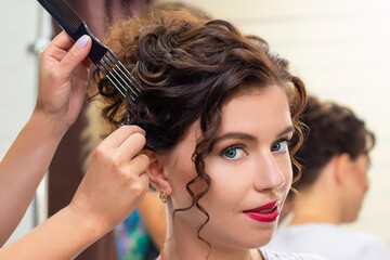 Fototapeta premium young woman in a beauty salon. Hairdresser makes hairstyle