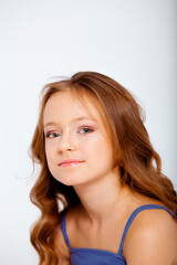 Naklejka premium dressed in a light blue dress on spaghetti straps cute little girl on a white background