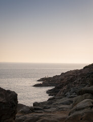 Marine landscape with fishermen on the rocks