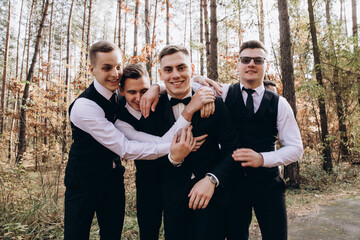 Cheerful, young, energetic witnesses of the groom next to the groom. Friends congratulate the groom. 