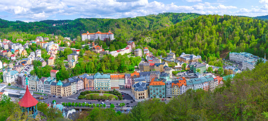 Karlovy Vary city aerial panoramic view with row of colorful multicolored buildings and spa hotels in historical city centre. Panorama of Karlsbad town and Slavkov Forest mountains, Czech Republic