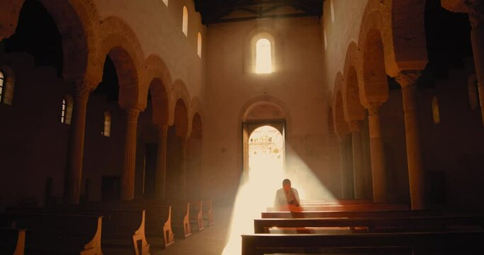 Vichingo o Normanno che prega in ginocchio dentro una chiesa