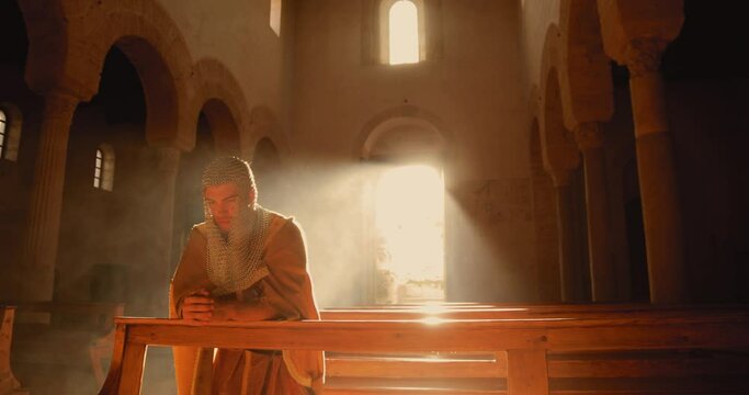 Vichingo o Normanno che prega in ginocchio in chiesa