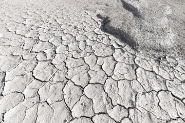 White soil cracked from the drought, top view. Background and texture to illustrate global environmental and climate change issues
