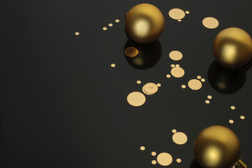 Three Christmas balls and golden confetti on a black background, Copy Space; Christmas Decoration, Christmas,  Christmas Toy