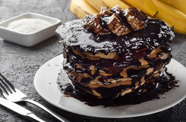 Pancakes and pancakes. Traditional pancakes with chocolate and banana on a dark background.