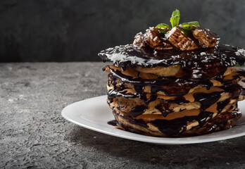 Pancakes and pancakes. Traditional pancakes with chocolate and banana on a dark background.