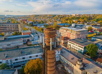 Aerial view of factory chimney in the city with 4G, 5G cellular network antennas