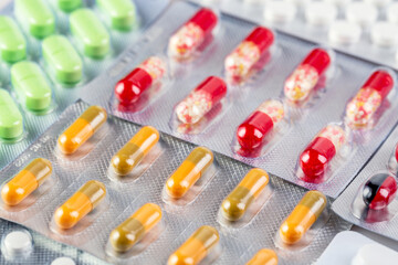 Medicine and healthcare background. Close up image of colorful medical pills and capsules in plastic packages