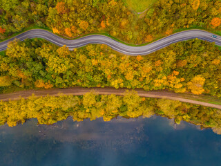 Aerial scenery view of winding road and railway beside in autumn fall