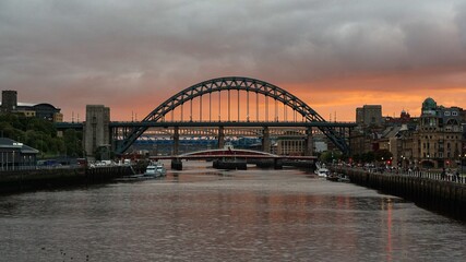Fototapeta na wymiar Sunset over the river Tyne in Newcastle upon Tyne, orange clouds behind the Tyne and the Swing bridges
