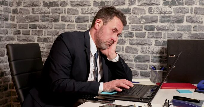 Business man unmotivated and bore out at laptop computer