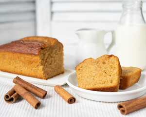 Homemade sponge cinnamon cake on white table, soft and moist dessert with milk. Homemade bakery concept for background, copy space, selective focus. Pound butter fluffy pie, white background.