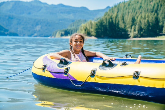 Happy Smiling Girl Floating On Lake In Innertube