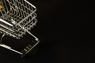Shopping cart on a black background. The concept of sales and discounts. Black Friday.