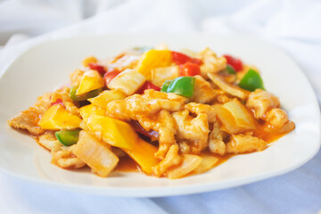 A view of a plate of sweet and sour chicken.