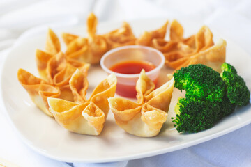 A view of a plate of cream cheese wontons.