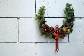 Christmas horseshoe wreath decorated with fir branches, Christmas balls and natural materials, New Year concept