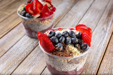 A view of acai bowls on a wooden surface.