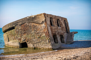 Liepaja beach bunker. Brick house, soft water, waves and rocks. Abandoned military ruins facilities