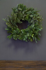 Fototapeta na wymiar Stylish minimalistic christmas fir branches wreath on gray background, copy space, greeting card