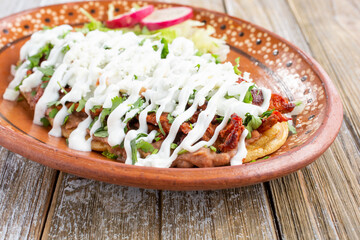 A view of a plate of huarache, in a restaurant or kitchen setting.