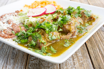 A view of a plate of chile verde, in a restaurant or kitchen setting.