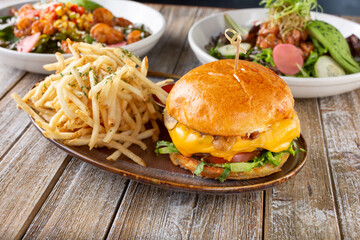 A view of several gastropub entree fare, featuring a cheeseburger and french fries plate.