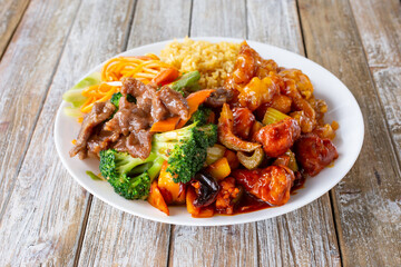 A view of a Chinese fast food 3-item combo plate, featuring beef broccoli, kung pao chicken, and orange chicken.