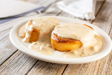 A view of a plate of biscuits and gravy, in a restaurant or kitchen setting.