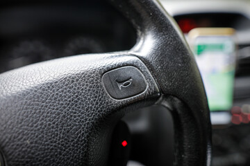 Shallow depth of field (selective focus) image with the honking button on the steering wheel of a...