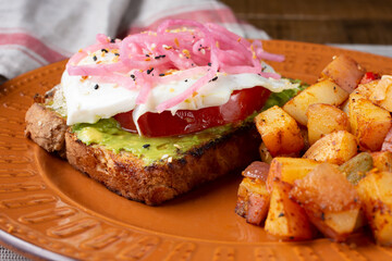 A view of a plate of avocado toast and roasted potatoes.