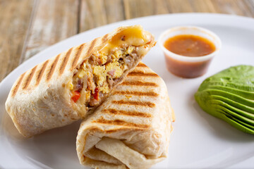 A view of a panini pressed breakfast burrito, in a restaurant or kitchen setting.