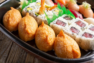 A view of a sushi platter, featuring several pieces of inari.