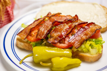 A view of a BLT sandwich, featuring bacon, lettuce and tomato.