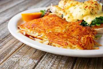 A view of a side portion of shredded hash browns, part of a breakfast entree, in a restaurant or kitchen setting.