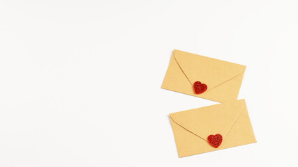 Two envilopes of craft paper with decorative hearts on the white background, isolated. Mock-up photo for any note for Sant Valentine's day.