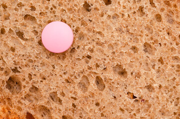 Pink tablet on a toast of bread