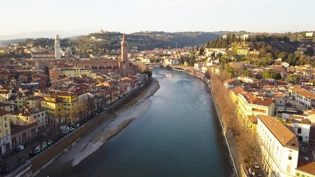 Verona, Italy. Aerial view of famous touristic city Verona in Italy at sunset. Bright sky with illuminated historical buildings.