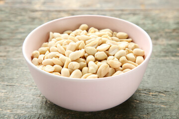 Peanuts in bowl on grey wooden table