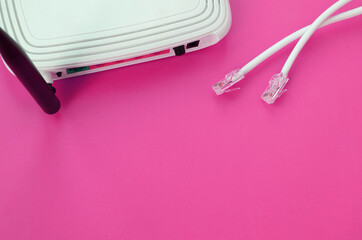 Internet router and Internet cable plugs lie on a bright pink background. Items required for...